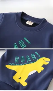 Détail du sweat à capuche dinosaure bleu marine pour enfant avec col côtelé et doublure polaire