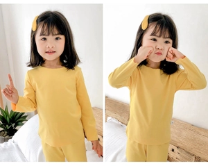 Détail de l'ensemble pyjama thermique jaune pour enfants avec poignets côtelés en coton doux