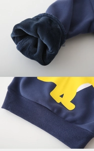 Détail d'un sweat bleu enfant avec doublure polaire épaisse et ourlet côtelé à imprimé jaune