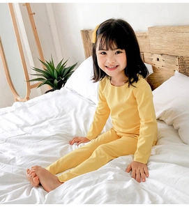 Détail d'un ensemble de sous-vêtements thermiques jaunes pour enfants dans une chambre