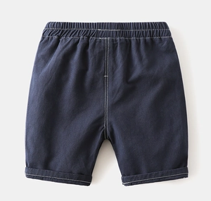 Détail du short en coton bleu foncé avec taille élastique et coutures blanches contrastées