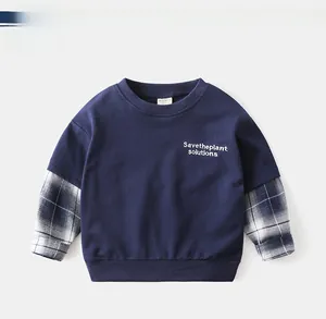 Detail of navy boy sweatshirt with layered plaid sleeves and printed text design