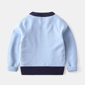 Detail of baby boy knit sweater back showing blue ribbed cuffs and hem texture