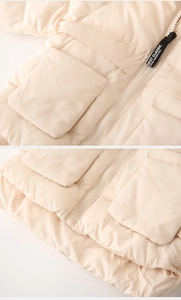 Detail of cream quilted vest featuring a premium zipper and large functional pockets