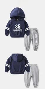 Détail d'un ensemble de sport pour enfant avec sweat à capuche bleu et pantalon gris