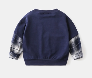 Detail view of boys' mock two-piece navy sweatshirt with blue plaid sleeves and ribbed cuffs