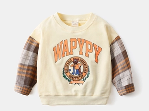 Detail of cream sweatshirt with orange plaid sleeves and cute bear graphic print