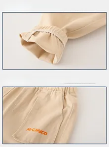 Détail des poignets élastiques et de la poche latérale avec broderie orange sur pantalon kaki