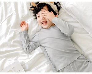 Pyjama thermique gris pour enfant montrant la texture douce de l'ensemble de nuit