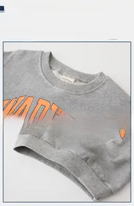 Close-up of gray kids sweatshirt showing rib-knit neckline and orange graphic print