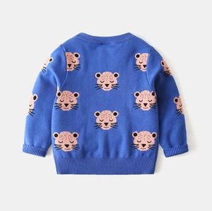 Close-up of blue knit sweater featuring pink cartoon leopard patterns and ribbed cuffs