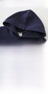 Détail du sweat à capuche bleu marine montrant la texture et l'imprimé 85 blanc