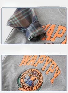Close-up of kids grey sweatshirt featuring plaid cuffs and orange WAPYPY cartoon print