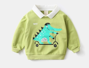 Detail of green kids' polo sweatshirt with cartoon crocodile print and white collar