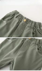 Detailed view of kids' olive green shorts featuring elastic waistband and white contrast stitching