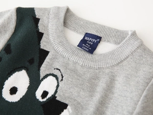 Detail of grey knitted sweater ribbed neckline with embroidered cartoon eye pattern