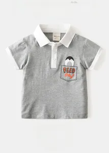Detail of grey boy's polo shirt showing embroidered penguin pocket and soft cotton fabric