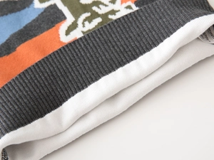 Macro detail of ribbed cuff and colorful geometric jacquard pattern on gray knit sweater