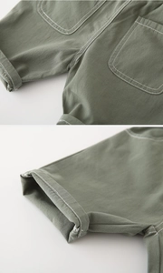 Detailed view of army green cotton shorts featuring neat stitching and folded hem details