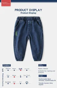 Detail view of boys' deep blue denim jeans featuring elastic waistband and green embroidery