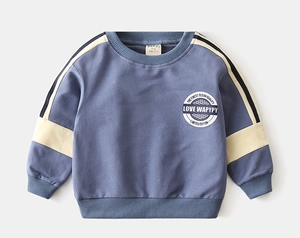 Detail of color-block boys' sweatshirt showing ribbed cuffs and retro circular print