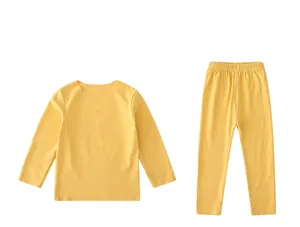 Détail de l'ensemble thermique jaune pour enfants avec poignets côtelés et étiquette