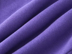 Close-up of premium purple knitted fabric texture showing soft stitching and quality weave