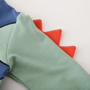 Detail der Dinosaurier-Flossen-Einsätze und weichen Baumwollstruktur auf dem Kinder-Hoodie