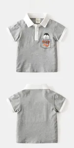 Detail of grey polo shirt featuring a contrast white collar and cute penguin chest pocket