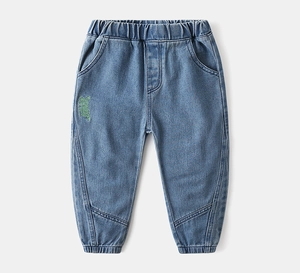 Detailed view of kids denim pants featuring green letter embroidery and elastic waistband