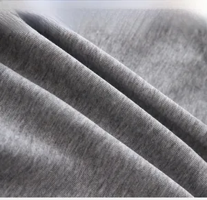Gros plan du tissu en coton tricoté gris montrant la texture détaillée et le tissage
