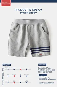 Détail du short en coton gris montrant la bande rayée et le patch graphique