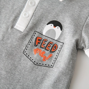 Detail of grey cotton polo shirt with penguin embroidery and Feed me text pocket
