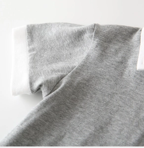 Close-up of heather grey knitted polo shirt showing white ribbed collar and soft texture