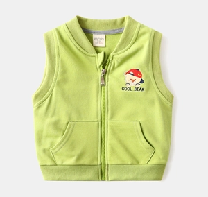 Détail d'un gilet vert pour enfant avec broderie d'ours et fermeture éclair métallique