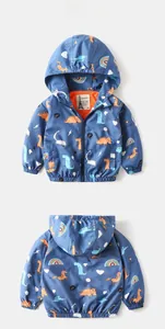 Detail of kids hooded jacket featuring colorful dinosaur prints and orange lining