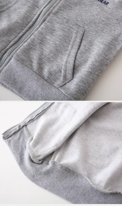 Détail de sweat pour enfant gris avec fermeture éclair, coutures et doublure bouclée