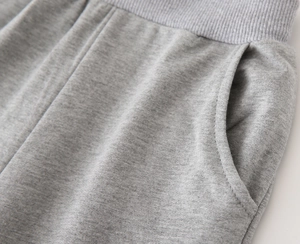 Détail du short de sport gris montrant la taille élastique côtelée et la couture latérale