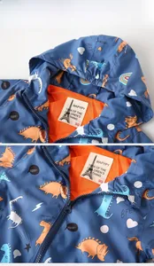 Detail of toddler hooded jacket showing orange mesh lining and blue dinosaur print