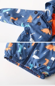 Detail of dinosaur print kids windbreaker with mesh lining and elastic waistband zipper