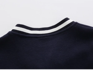 Detail of navy blue knitted V-neck sweater with white striped neckline and soft texture