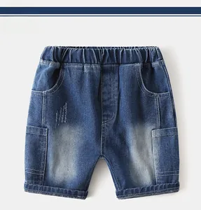 Close-up of boys denim shorts featuring elastic waist and distressed cat-whisker details