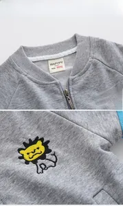 Detail of baby zipper cardigan showing lion embroidery and stitched inner neck label