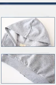 Détail d'un gilet gris à capuche montrant l'ourlet côtelé et l'étiquette de taille