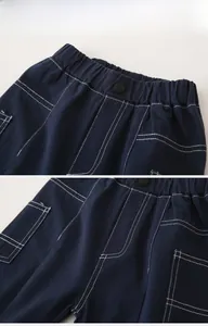 Detail of navy cotton boys cargo pants featuring contrast stitching and elastic waistband