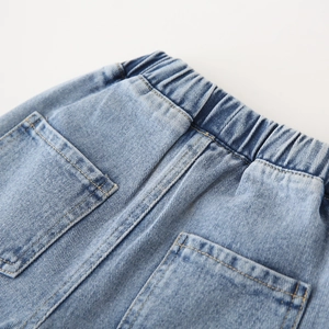 Détail de la taille élastique et des coutures jaunes sur le pantalon en denim bleu clair