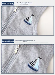 Vue macro de la broderie de voilier et des poignets côtelés sur le gilet gris enfant
