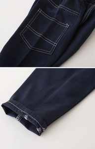 Detailed view of dark blue cotton trousers featuring white contrast stitching and rear pocket