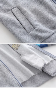 Detail of gray zip-up cardigan showing side pocket stitching and soft loopback fabric
