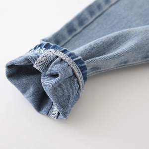Détail des poignets élastiques avec surpiqûres blanches sur ce pantalon en jean bleu clair